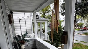 A covered porch with a bench, a potted plant, and a doorbell. - Villages romantic house at Ridgfield near nyc (Ridgefield Park)
