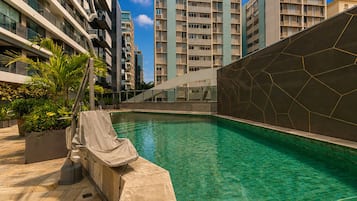Una piscina al aire libre, sillones reclinables de piscina