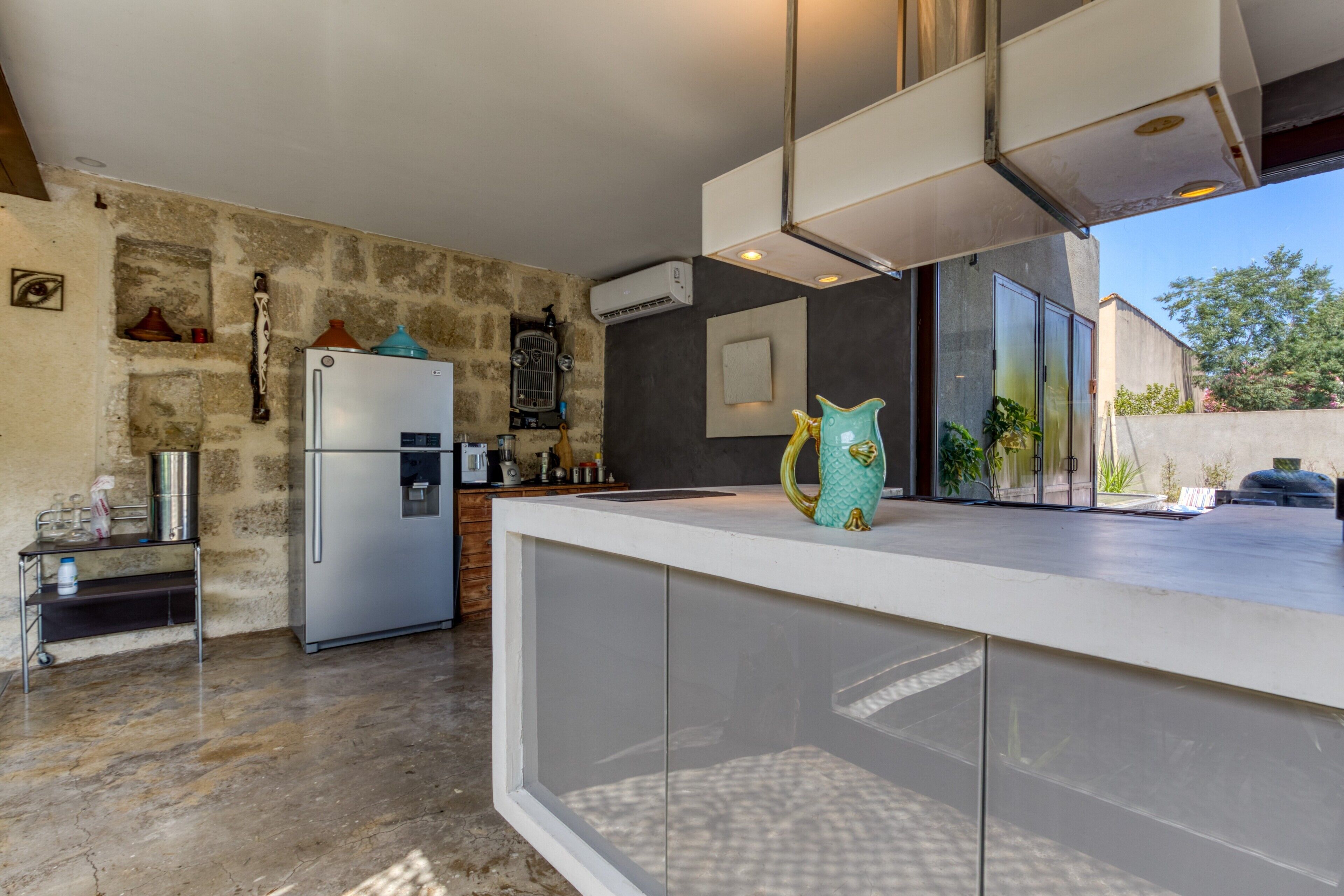Una cocina moderna con refrigerador, dispensador de agua y vitrina de vidrio.