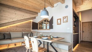 Habitación estilo loft con una mesa de comedor, sillas, un sofá y un amplio ventanal.
