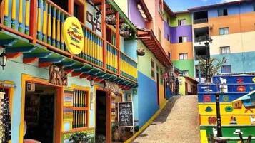 A colorful street with a building that has a sign for a restaurant.
