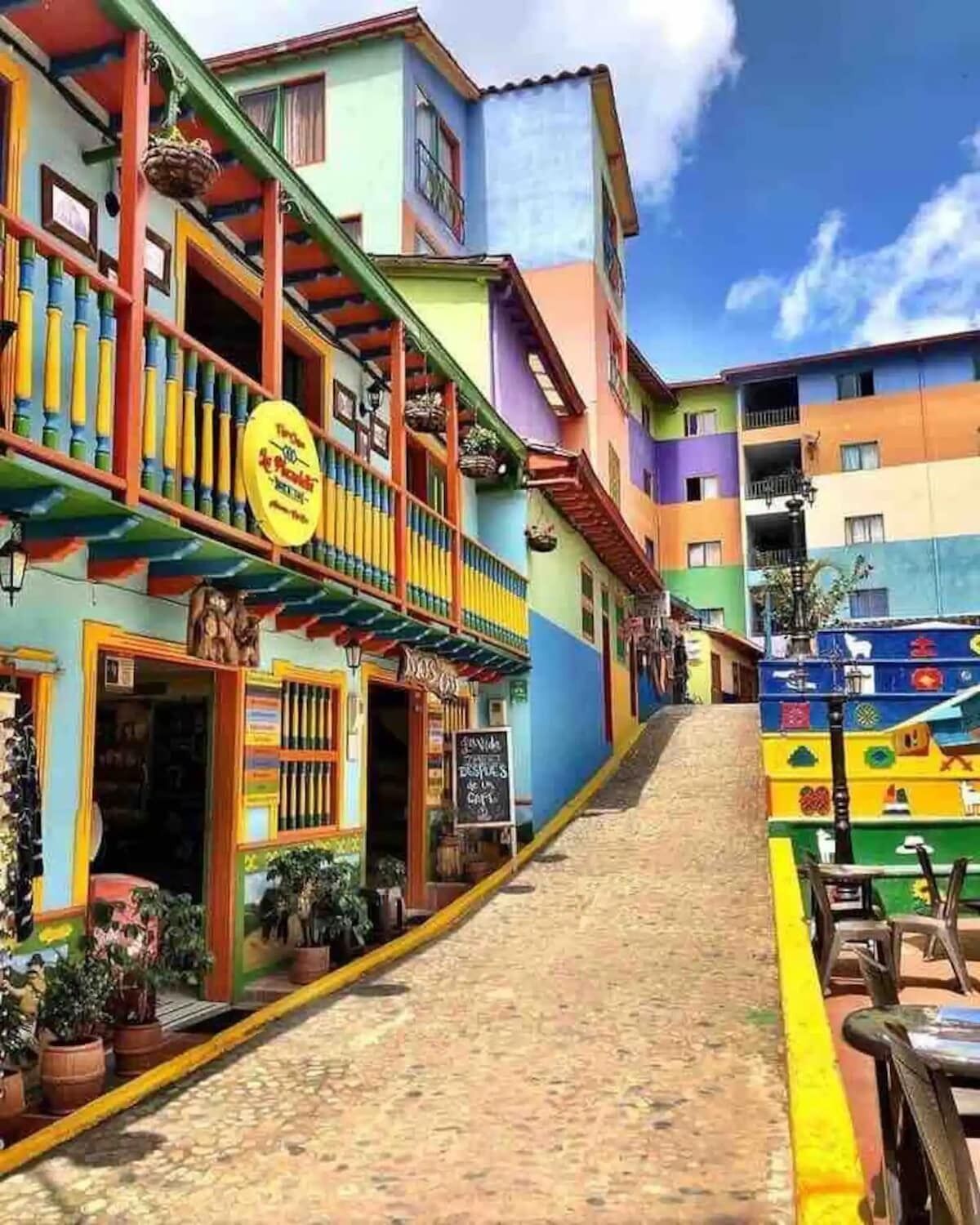 A colorful street with a building that has a sign for a restaurant.