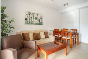 Una sala de estar con un sofá, una mesa de centro y un comedor con sillas y una mesa.