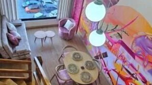 A modern interior with a wooden staircase, a dining area with a round table and chairs, and a vibrant mural on the wall. - Historic Downtown - Modern Loft - Toque Cocha - Quillak (Nariño)