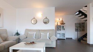 Un salon moderne avec un canapé, une table basse et des miroirs fixés au mur.