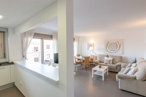 A modern apartment with a kitchen, dining area, and living room. - Apartment 'Cala Gaviota' with Sea Views, Wi-Fi, and Air Conditioning (Colònia de Sant Jordi)