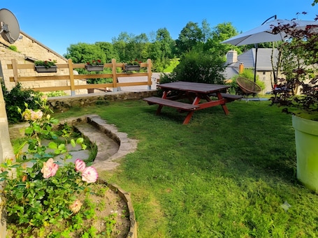 A backyard with a wooden fence, a picnic table, and a stone pathway.. La ch'tiote meizou: private garden, peaceful and relaxing getaway