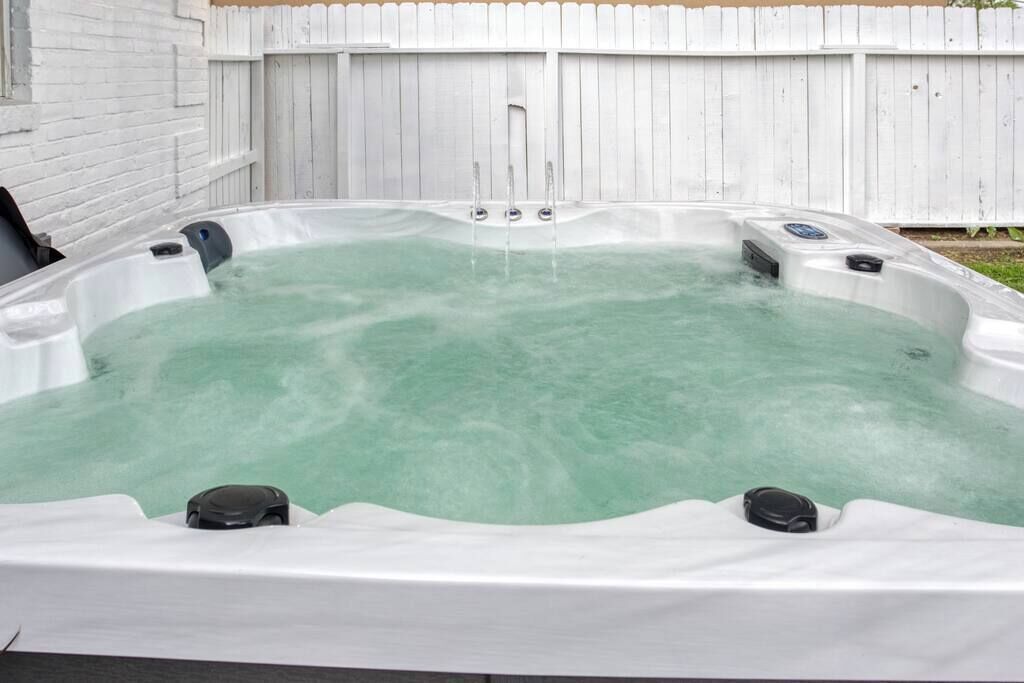 Un bain à remous avec une clôture en bois en arrière-plan.
