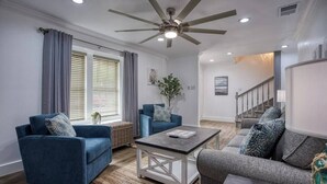 Ein Wohnzimmer mit zwei Sofas, einem Couchtisch und einem Deckenventilator.