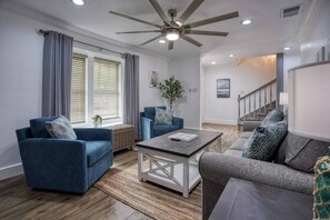 Ein Wohnzimmer mit zwei Sofas, einem Couchtisch und einem Deckenventilator.