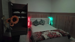 A bedroom with a bed, a wardrobe, and a nightstand.