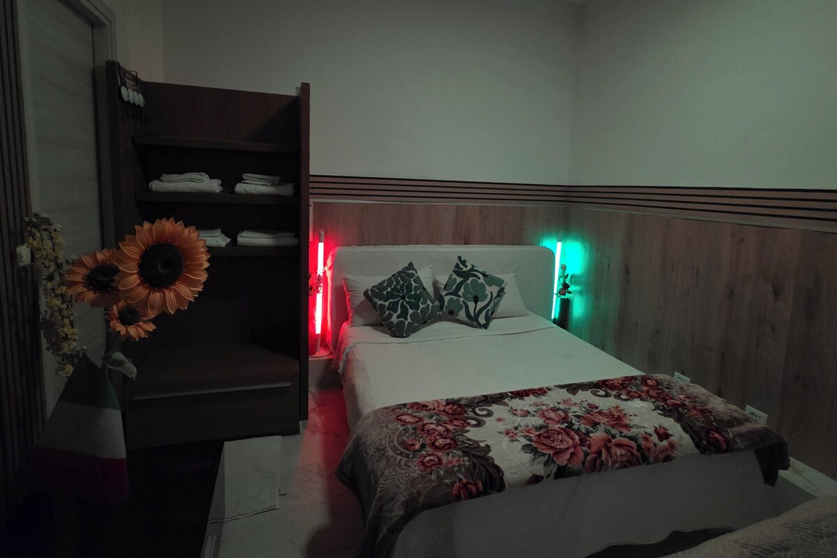 Un dormitorio con una cama, un armario y una mesita de noche.