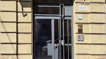 Ein Gebäudeeingang mit einem Metallgitter, einer Tür und einem Schild mit der Aufschrift 'CONDOMINIO 22'.