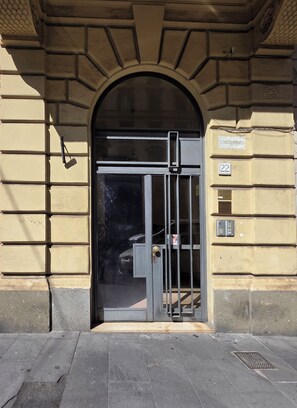 Entrada de un edificio con una puerta metálica, una puerta y un cartel que dice 'CONDOMINIO 22'.