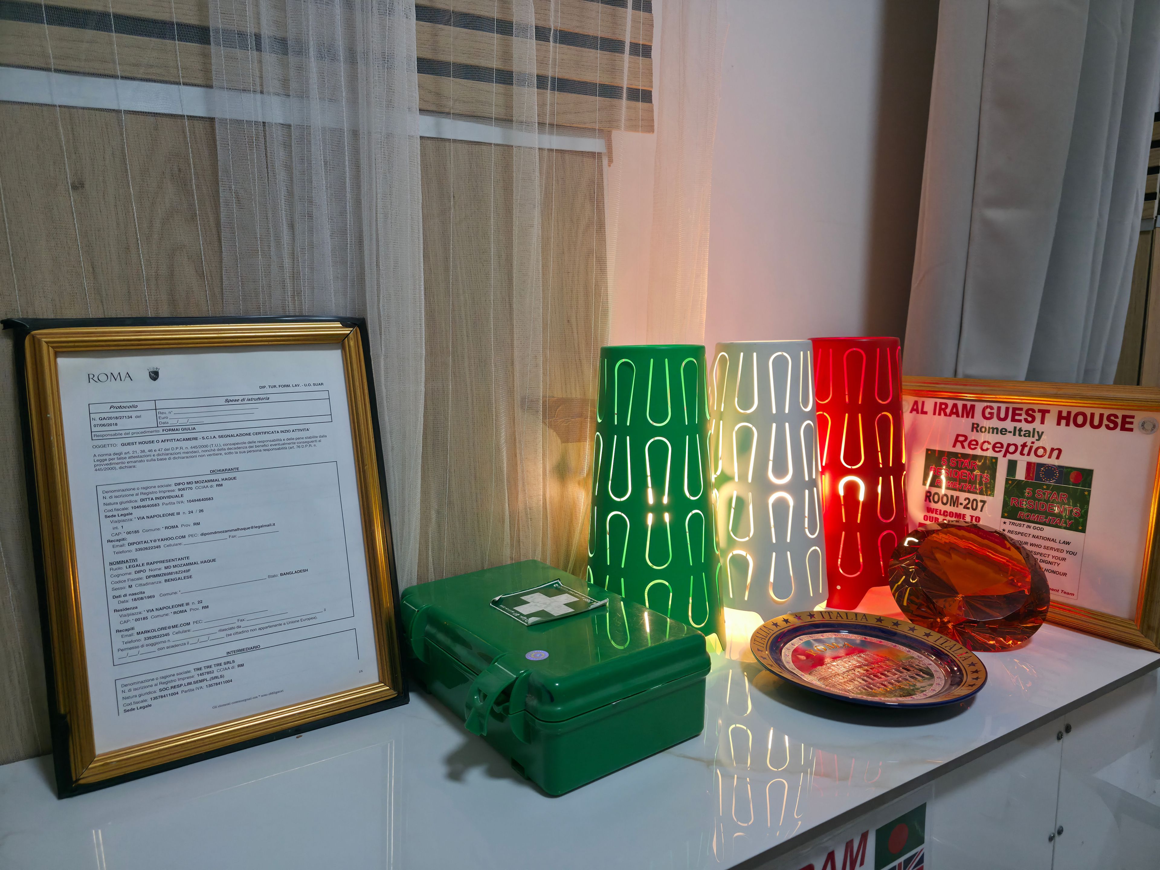A framed document, a green briefcase, and a reception sign with a globe and stars.