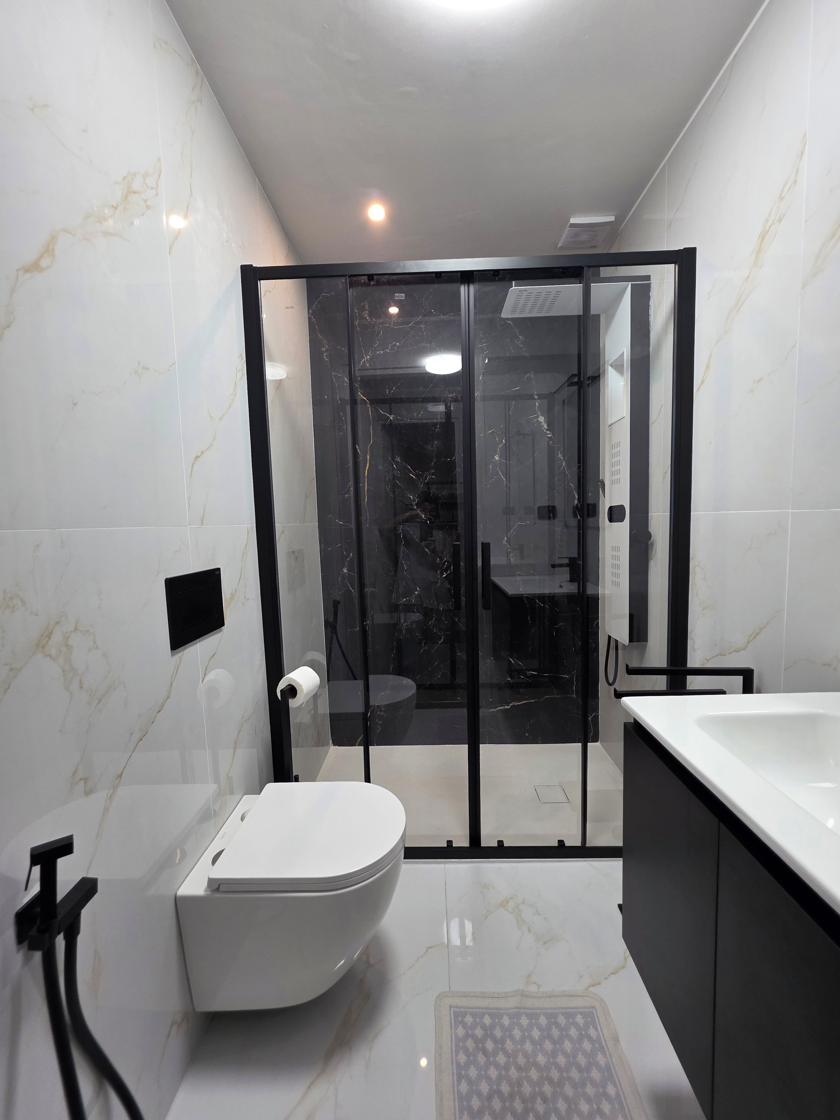 A modern bathroom with a toilet, a shower area, and a bathtub.