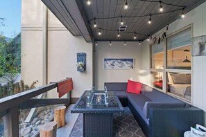 An outdoor patio with a glass-top table, a sofa, and a view of a mountain. - Luxe 2-Bed | Ski-in Ski-out | On Hill (Whistler)