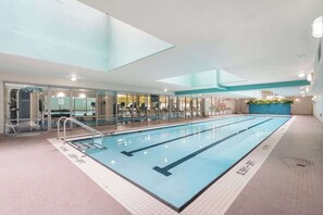 Ein Hallenbad mit deutlichen Bahnen, einer Glaswand auf der einen Seite und einer blauen Akzentwand.