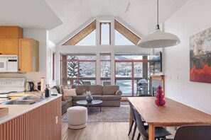 A modern kitchen with a dining area, large windows, and a loft space. - Cozy Lakefront Whistler Condo -Mountain, Lake View (Whistler)