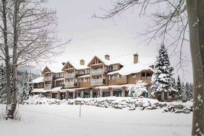A multi-story lodge with a symmetrical facade, large windows, and a snow-covered roof. - Cozy Lakefront Whistler Condo -Mountain, Lake View (Whistler)
