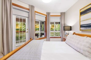 A hotel room with a bed, a nightstand, a lamp, and two windows with curtains. - 3-BDRM | Whistler Village | Walk to Hill | Hot Tub (Whistler)