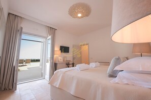 Ein Hotelzimmer mit einem großen Bett, einem Schreibtisch und Blick ins Freie.