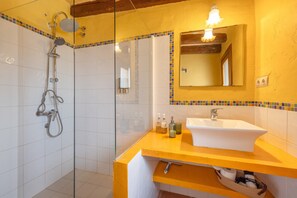 A bathroom with a glass shower enclosure, a white sink, and a mirror above it. - Apartment 'Cal Capdevila Blau' with Mountain View, Wi-Fi and Air Conditioning (Pira)