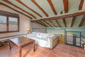 Una stanza accogliente con soffitto in legno, un divano, un tavolo e una finestra con vista sulla città.