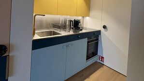 A compact kitchen with a sink, stove, and a coffee maker on the counter. - Coastal Couple Hideaway in Oostduinkerke (Koksijde)