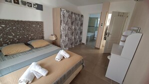 Una habitación de hotel con cama, baño y zona de ducha.