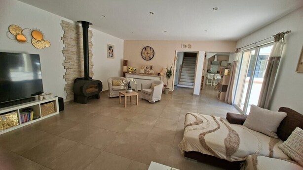 Una sala de estar con televisión, chimenea, sofá y comedor.