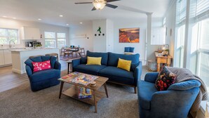 A modern living room with a sofa, coffee table, and a ceiling fan.