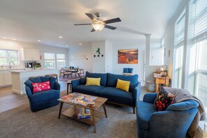 A modern living room with a sofa, coffee table, and a ceiling fan. - Grand Canyon Escape in Williams sleeps 6 (Williams)