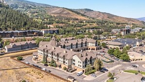 Un hôtel à plusieurs étages doté d’une cour intérieure, entouré d’un paysage montagneux.