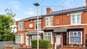 A two-story residential building with a visible satellite dish, a door with a small window, and a sign indicating a leisure center car park. - 3-Bed Bearwood | Midland Met, No CAZ, Free Parking (Smethwick)