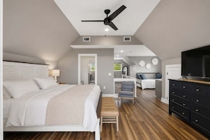 A bedroom with a bed, bedside table, lamp, ceiling fan, and a TV on a dresser. - New- Seabreeze-Bay Front -Pet Friendly (Eastpoint)