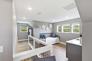 Un dormitorio con una cama, un escritorio y una ventana.
