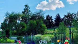 A playground with swings, slides, and climbing structures. - The Unusual Getaway • Nature Chalet & Hot Tub (Meilhac)