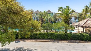 A resort with multiple buildings, a swimming pool, and lush greenery. - Mins from Beach • Sleeps 17 • Outdoor Seating (Destin)