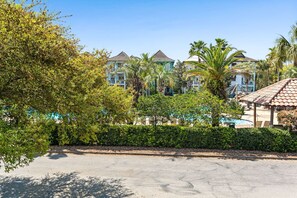 A resort with multiple buildings, a swimming pool, and lush greenery. - Mins from Beach • Sleeps 17 • Outdoor Seating (Destin)