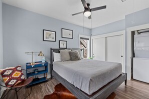 A bedroom with a bed, a ceiling fan, a nightstand, a chair, a rug, and a wardrobe. - Walnut Retreat | Hot Tub,  Gas Fireplace & AC (Sandpoint)