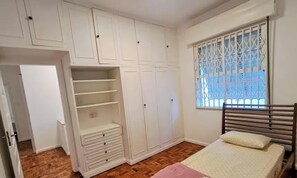 Ein Schlafzimmer mit Bett, Kleiderschrank und einem Fenster mit Blick.