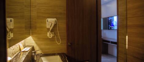 A modern bathroom with a marble sink, a hand dryer, and a mirror.
