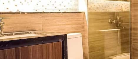 Un baño con tocador de madera, inodoro y cabina de ducha de vidrio.