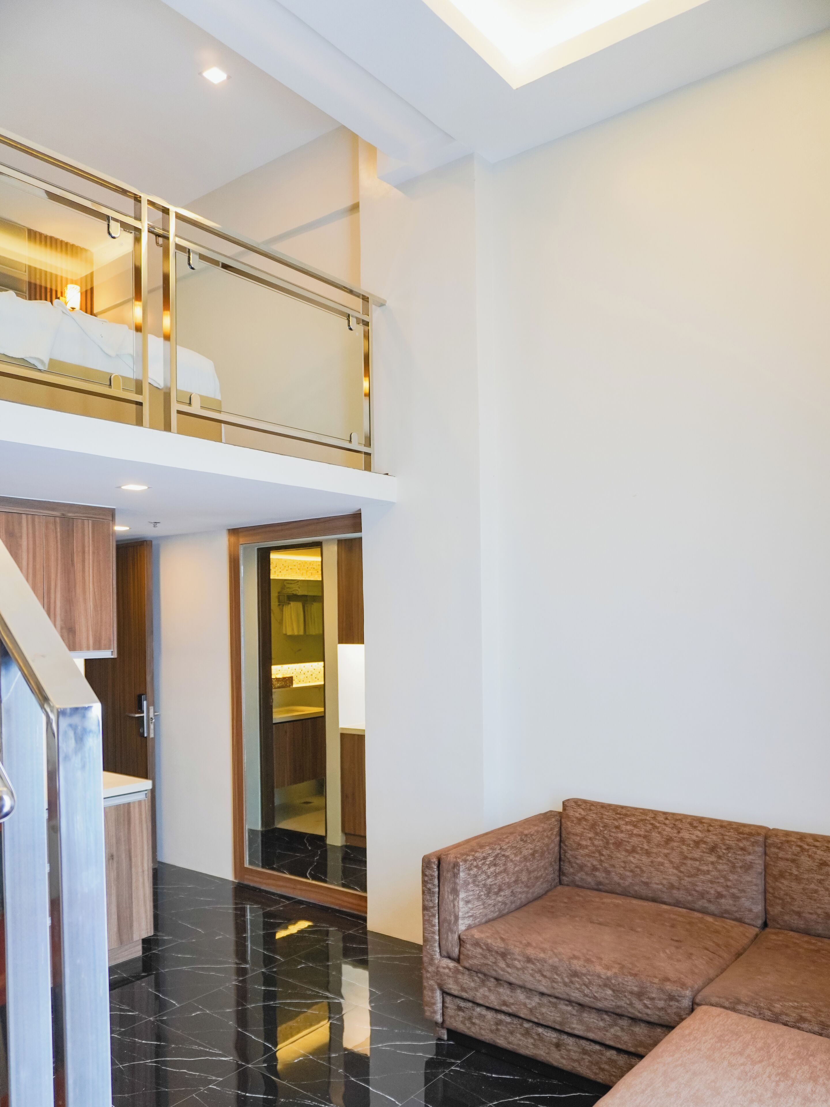 A modern interior with a staircase, a sofa, and a bathroom.