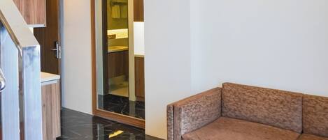 A modern interior with a staircase, a sofa, and a bathroom.