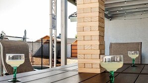 En utomhusplats med ett bord, stolar och två glas vitt vin.