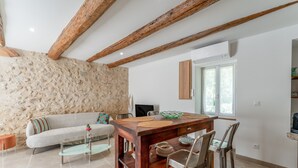 Ein Essbereich mit einem Holztisch, Stühlen und einer Steinwand.