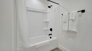 A bathroom with a shower, a bathtub, and a towel rack. - The Lawson District | Marigold Suite (Midlothian)