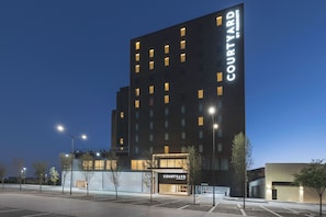 Un hôtel moderne, avec une enseigne « Courtyard by Marriott » au-dessus de l’entrée.